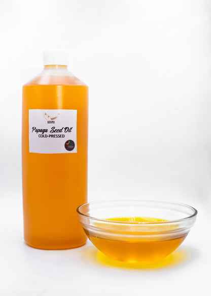 Bottle and bowl of papaya seed oil on a white background