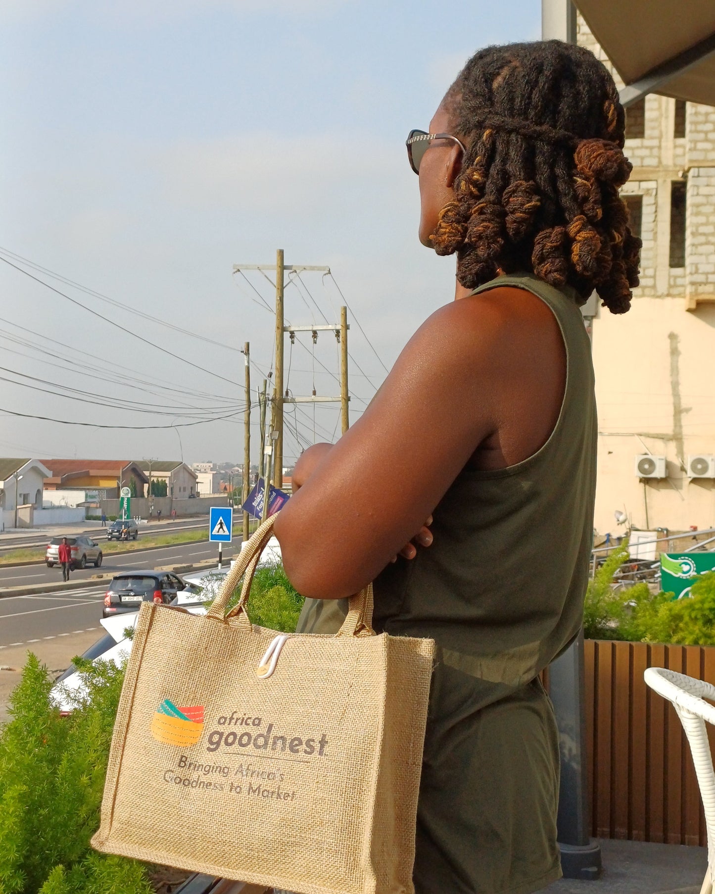 Person holding a Goodnest bag with a cityscape background